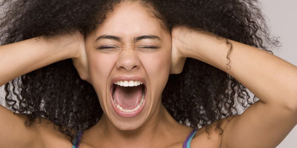 Woman screaming with hands over her ears